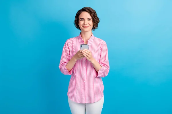 Foto de chica alegre positiva mantenga el teléfono celular use ropa formal aislada sobre fondo de color azul —  Fotos de Stock