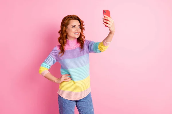 Bir elinde telefonuyla selfie çeken bir kadının fotoğrafı. Renkli pastel arka planda izole edilmiş. — Stok fotoğraf