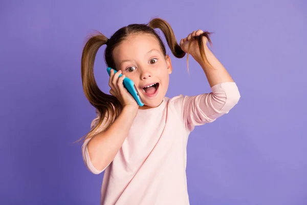 Foto de caudas marrom cabelo menina usar jumper talk no telefone espantado segure pigtail isolado no fundo cor violeta — Fotografia de Stock