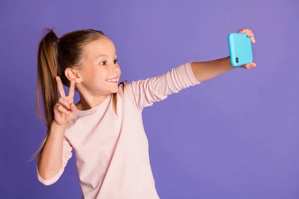 Foto de las colas de pelo castaño niña usar suéter teléfono de retención hacer selfie v-signo aislado sobre fondo de color púrpura —  Fotos de Stock