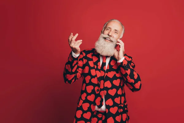 Photo du vieil homme tenir le téléphone communiquer lever les mains regarder vide espace porter coeur impression tux isolé fond rouge — Photo