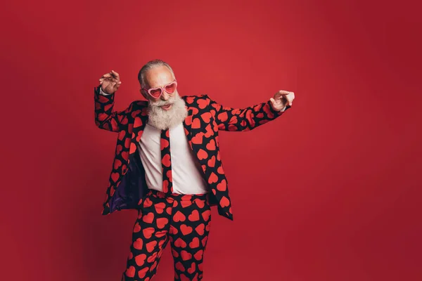 Kaygısız yaşlı adamın eski moda disko dansının fotoğrafı. Kalp izi elbisesi, izole edilmiş kırmızı arka plan. — Stok fotoğraf