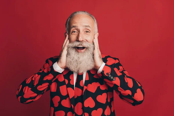 Photo de l'homme retraité drôle étonnant toucher barbe blanche bouche ouverte porter coeur impression tux isolé fond rouge — Photo