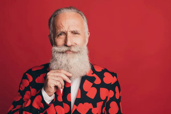 Photo de sérieux homme mature toucher élégante barbe blanche porter coeur impression smoking isolé fond rouge — Photo