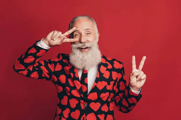 Photo de barbu retraité danse bouche ouverte montrer deux v-signes porter costume imprimé coeur isolé fond rouge — Photo