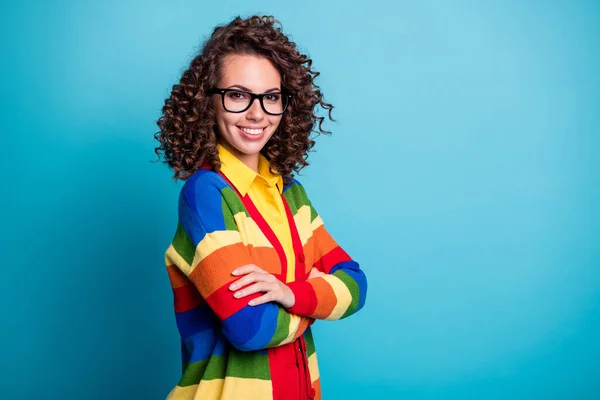 Portrait of beautiful young girl curly brunette hair happy smile crossed hands isolated over blue color background — Stock Photo, Image