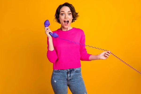 Fénykép a megdöbbent lány hívás telefon hallgatni információ kopás jumper farmer elszigetelt ragyogás színes háttér — Stock Fotó