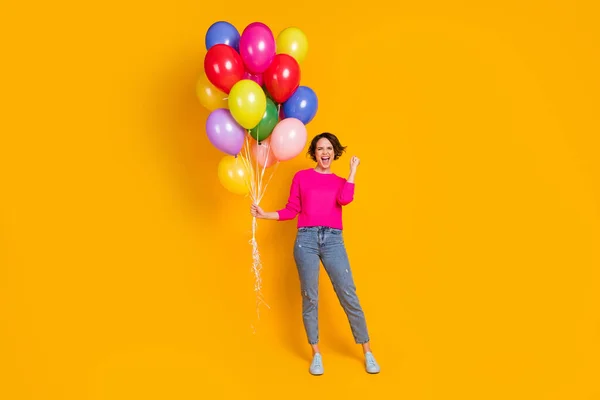 Foto de tamaño completo de la chica extática mantenga globos ganar levantar los puños usar jersey aislado color brillante fondo — Foto de Stock