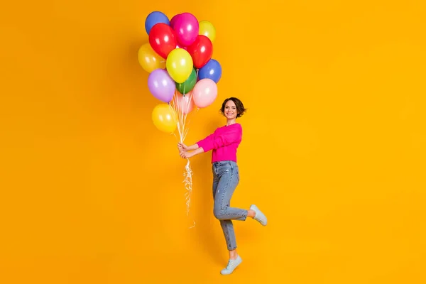 Foto in voller Größe von offenen Mädchen halten viele Luftballons tragen Pullover isoliert über lebendigen Farbhintergrund — Stockfoto