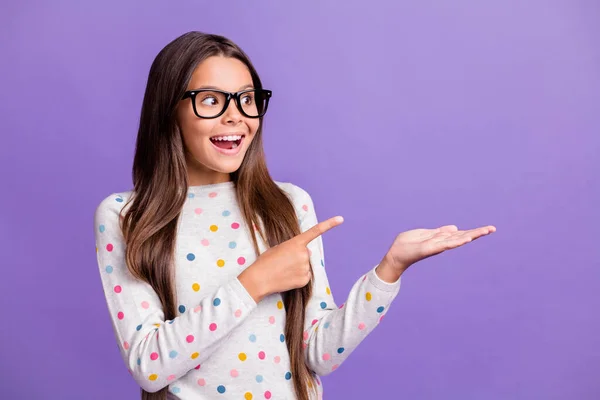 Foto retrato de estudante em óculos apontando para copyspace na palma sorrindo isolado no fundo cor roxa brilhante — Fotografia de Stock