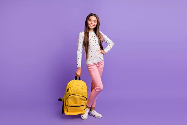 Full length body size photo of sweet cute little girl keeping bag wearing casual clothes sneakers izolowane na żywe fioletowe tło — Zdjęcie stockowe
