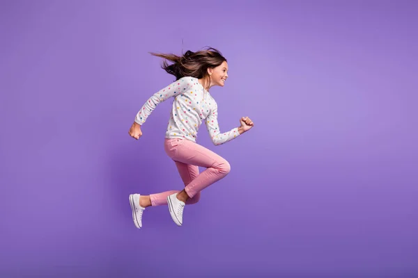 Volledige lengte lichaam grootte zijkant profiel foto van springen hoog lopende snelle schoolmeisje glimlachen geïsoleerd op heldere violette kleur achtergrond — Stockfoto