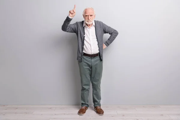 Full storlek foto av gammal ledsen man finger upp bära mörk tröja byxor stövlar isolerad på grå vägg — Stockfoto