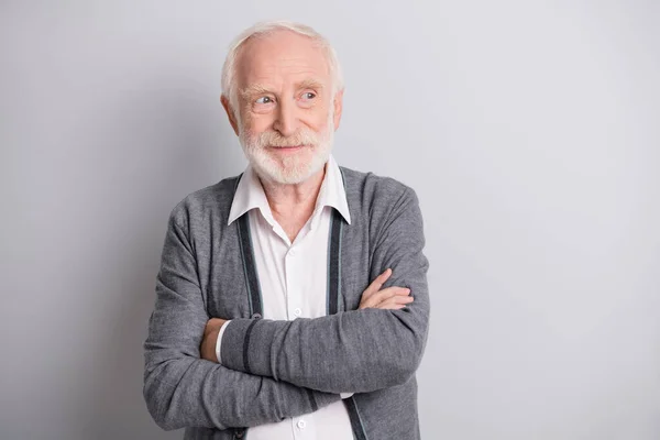 Photo de vieil homme optimiste bras croisés regarder espace vide porter pull foncé isolé sur fond gris — Photo