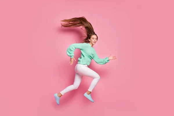 Foto de tamaño completo de atractiva persona deportiva salto correr suéter de color verde azulado rápido aislado en el fondo de color rosa —  Fotos de Stock