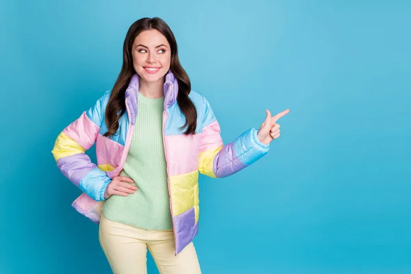 Photo of young girl look show point finger empty space choice choose promo ad wear yellow pants isolated over blue color background — Zdjęcie stockowe