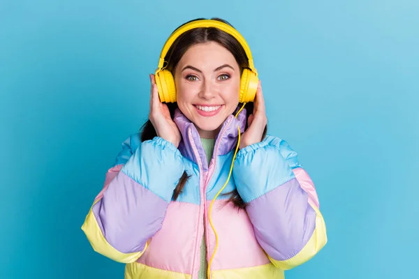 Φωτογραφία πορτρέτο του χαρούμενος κορίτσι φορώντας κίτρινα ακουστικά που απομονώνονται σε παστέλ μπλε χρώμα φόντο — Φωτογραφία Αρχείου