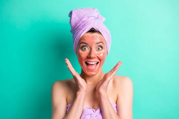 Porträt von erstaunt attraktive Person Gesichtsmaske Arme unter offenem Mund lila Handtuch isoliert auf Krickente Farbe Hintergrund — Stockfoto
