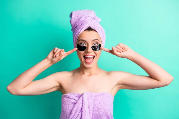 Foto von aufgeregten Mädchen Patches unter den Augen direkte Finger offenen Mund tragen lila Handtuch Turban isoliert Krickente Farbe Hintergrund — Stockfoto