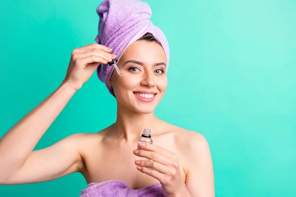 Photo of charming girl hold bottle pipette apply essence face wear purple towel turban isolated turquoise color background — Stock Photo, Image