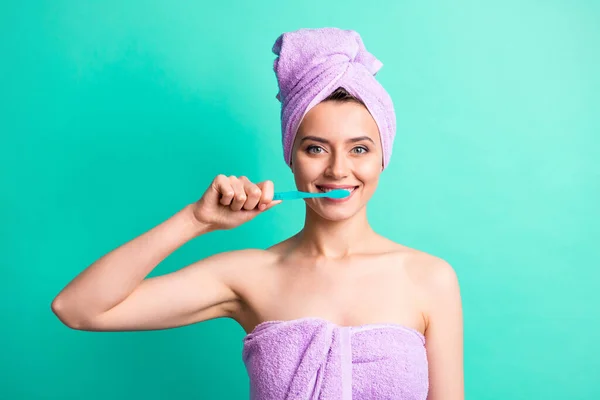 かなり健康的な女の子の写真を保持歯ブラシ洗って歯を見てカメラは、紫色のタオルターバン隔離された歯の色の背景を着用 — ストック写真