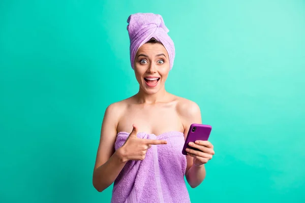美しい女性の写真を保持電話直接指デバイス画面を着用バイオレットタオル隔離されたカラー背景 — ストック写真