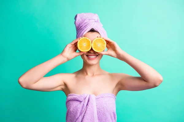 Retrato de la señora divertida que cubre los ojos rebanadas de naranja como los prismáticos usan toallas violetas fondo de color verde azulado aislado —  Fotos de Stock