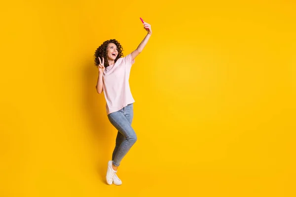 Full length body size photo of female millennial taking selfie showing v-sign isolated on vivid yellow color background with copyspace — Stock Photo, Image
