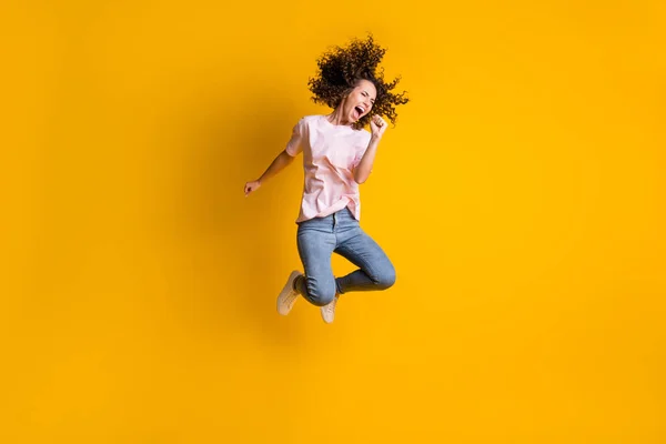 Foto retrato de cuerpo completo de la niña gritando en el micrófono imaginario saltando aislado sobre fondo de color amarillo vivo —  Fotos de Stock