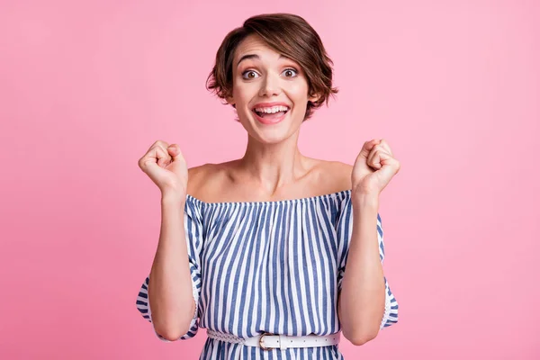 Foto portret van vrolijk meisje met vuisten omhoog geïsoleerd op pastel roze gekleurde achtergrond — Stockfoto