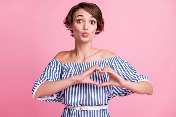 Foto porträtt av pip flicka att göra hjärta form på bröstet med händerna isolerade på pastell rosa färgad bakgrund — Stockfoto
