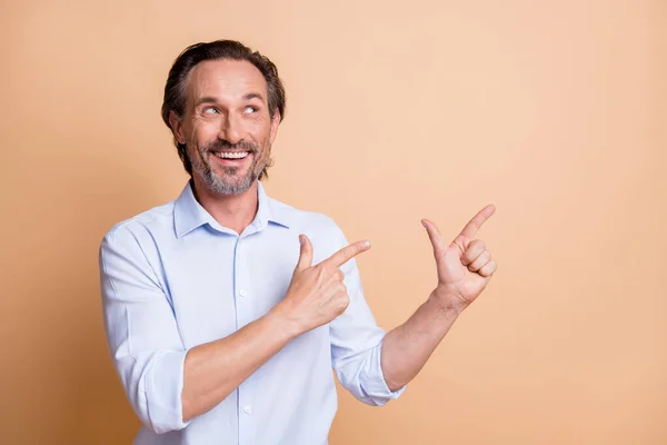 Retrato de bom homem inteligente alegre demonstrando cópia espaço vazio anúncio isolado sobre fundo cor pastel bege — Fotografia de Stock