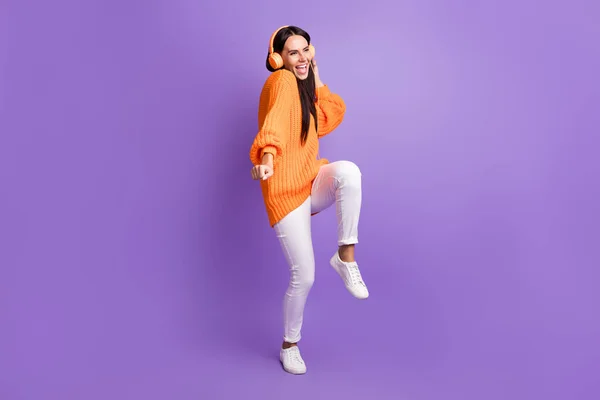 Foto de tamaño completo de la danza chica funky optimista escuchar canción usar suéter rojo pantalones zapatillas aisladas sobre fondo lila —  Fotos de Stock