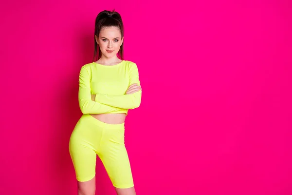 Foto de linda mujer joven fuerte vestido amarillo ropa deportiva manos cruzadas aislado color rosa fondo — Foto de Stock