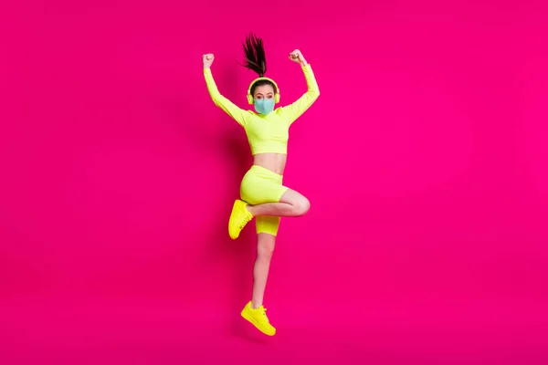 Full length body size photo of sportswoman jumping showing strong hands φορώντας ακουστικά μάσκας απομονωμένα σε φωτεινό φούξια χρώμα φόντου — Φωτογραφία Αρχείου