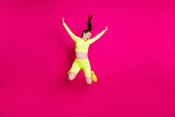 Volledige lichaamslengte foto van springen hoge schreeuwen energieke sportvrouw lachen geïsoleerd op fel roze kleur achtergrond — Stockfoto