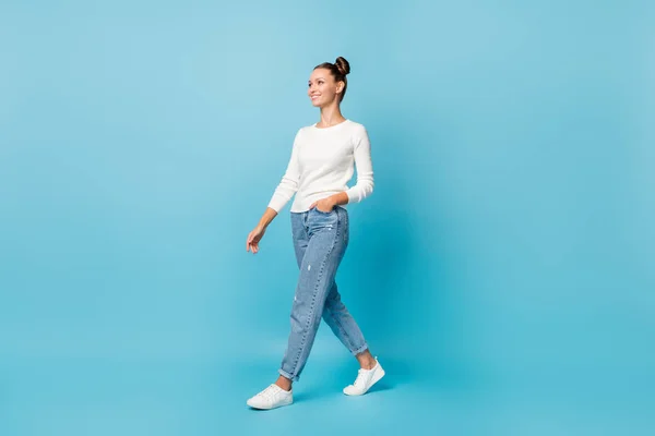 Foto de niña de ensueño caminar bolsillo de mano desgaste suéter blanco jeans calzado aislado color azul fondo — Foto de Stock