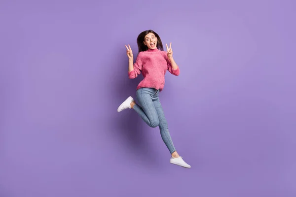 Ganzkörpergröße Foto von springen hohe verrückte Frau zeigt V-Zeichen Geste isoliert auf lebendigen violetten Farbhintergrund — Stockfoto