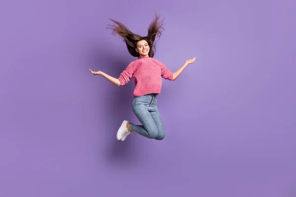 Longitud completa tamaño del cuerpo foto de la mujer saltando lanzando el pelo sonriente con pantalones vaqueros jersey aislado en vibrante color violeta fondo —  Fotos de Stock
