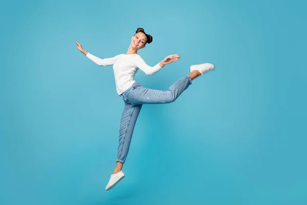 Full length photo of girl jump dance ballet wear white sweater jeans sneakers isolated blue color background — Stock Photo, Image
