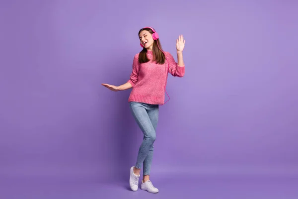 Full length body size φωτογραφία μιας φοιτήτριας που γελάει φορώντας ακουστικά χορεύοντας απομονωμένη σε φωτεινό μωβ φόντο — Φωτογραφία Αρχείου