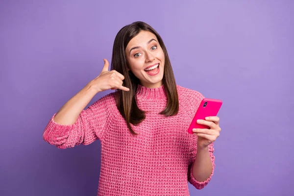 Foto retrato de morena feminina feliz mostrando gesto me chame sorrindo mantendo o celular isolado no fundo de cor roxo vívido — Fotografia de Stock