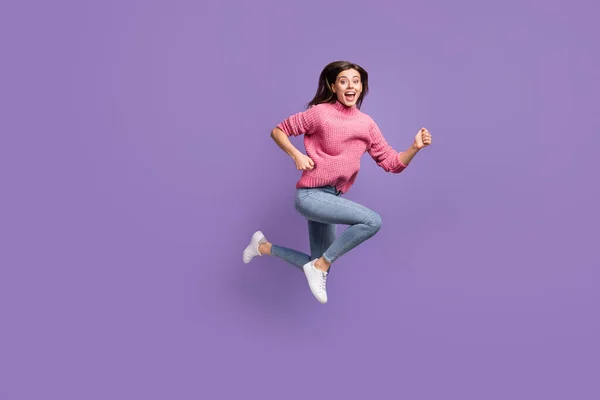 Full size profiel portret van aantrekkelijke onder de indruk dame sprong run open mond slijtage trui geïsoleerd op violette kleur achtergrond — Stockfoto