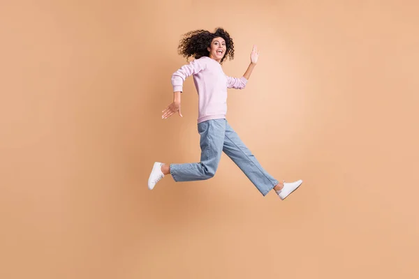 Foto de perfil de tamaño completo de la persona enérgica correr saltar boca abierta prisa aislado sobre fondo de color marrón —  Fotos de Stock