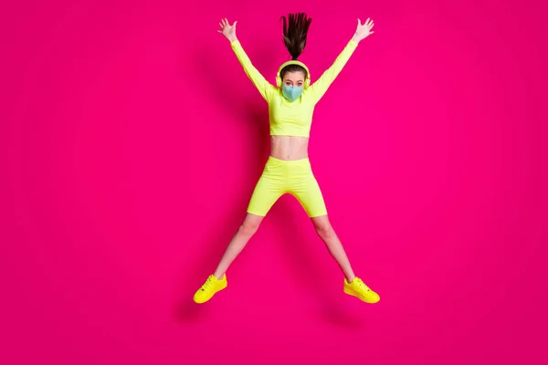 Foto de cuerpo entero del tamaño de la muchacha que salta como estrella que usa auriculares ropa deportiva amarilla aislada en fondo de color fucsia brillante — Foto de Stock