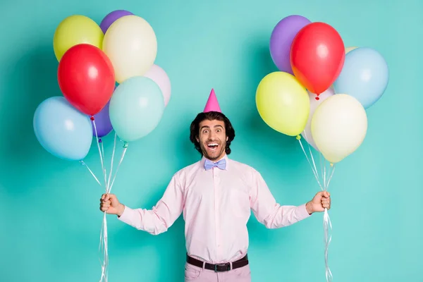 Retrato de louco humor cara levantar espera colorido hélio balões desgaste camisa rosa cone isolado no turquesa cor fundo — Fotografia de Stock