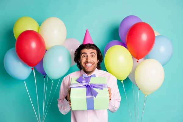 Retrato de magnífico chico entregar presente caja coloridos globos de helio desgaste formal tapa de cono aislado sobre fondo de color turquesa — Foto de Stock