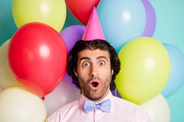 Retrato de homem chocado boca aberta desgaste cone cap rosa camisa roxo arco isolado muitos balões criativo fundo — Fotografia de Stock