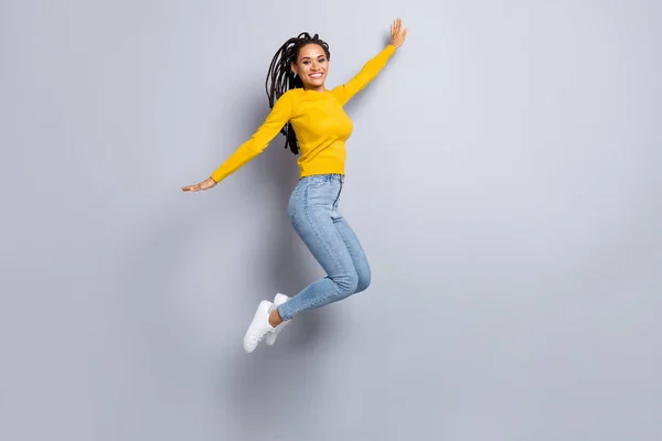 Plná velikost fotografie mladé veselý afro dívka blázen těšit šťastný úsměv vyskočit izolované přes šedou barvu pozadí — Stock fotografie