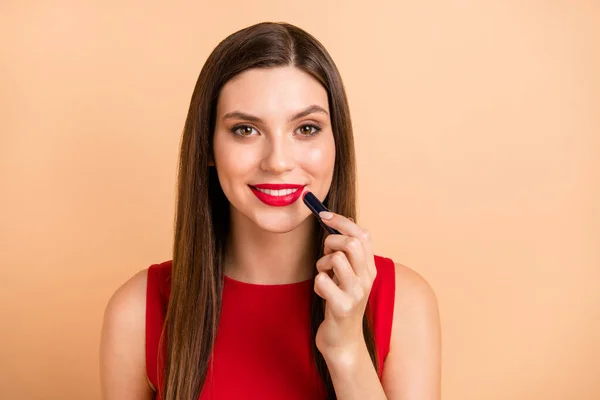 Foto de impresionante dama glamour agradable aplicar lápiz labial rojo desgaste singlet aislado sobre fondo de color beige pastel — Foto de Stock